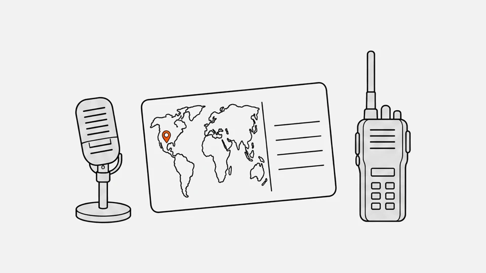 A QSL card with a world map and a pin on the station's location, between a desk microphone and a handheld radio